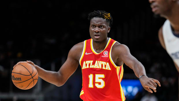 Atlanta Hawks center Clint Capela points to a teammate while dribbling.